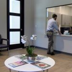 Man at reception desk in waiting area at {PRACTICE_NAME}